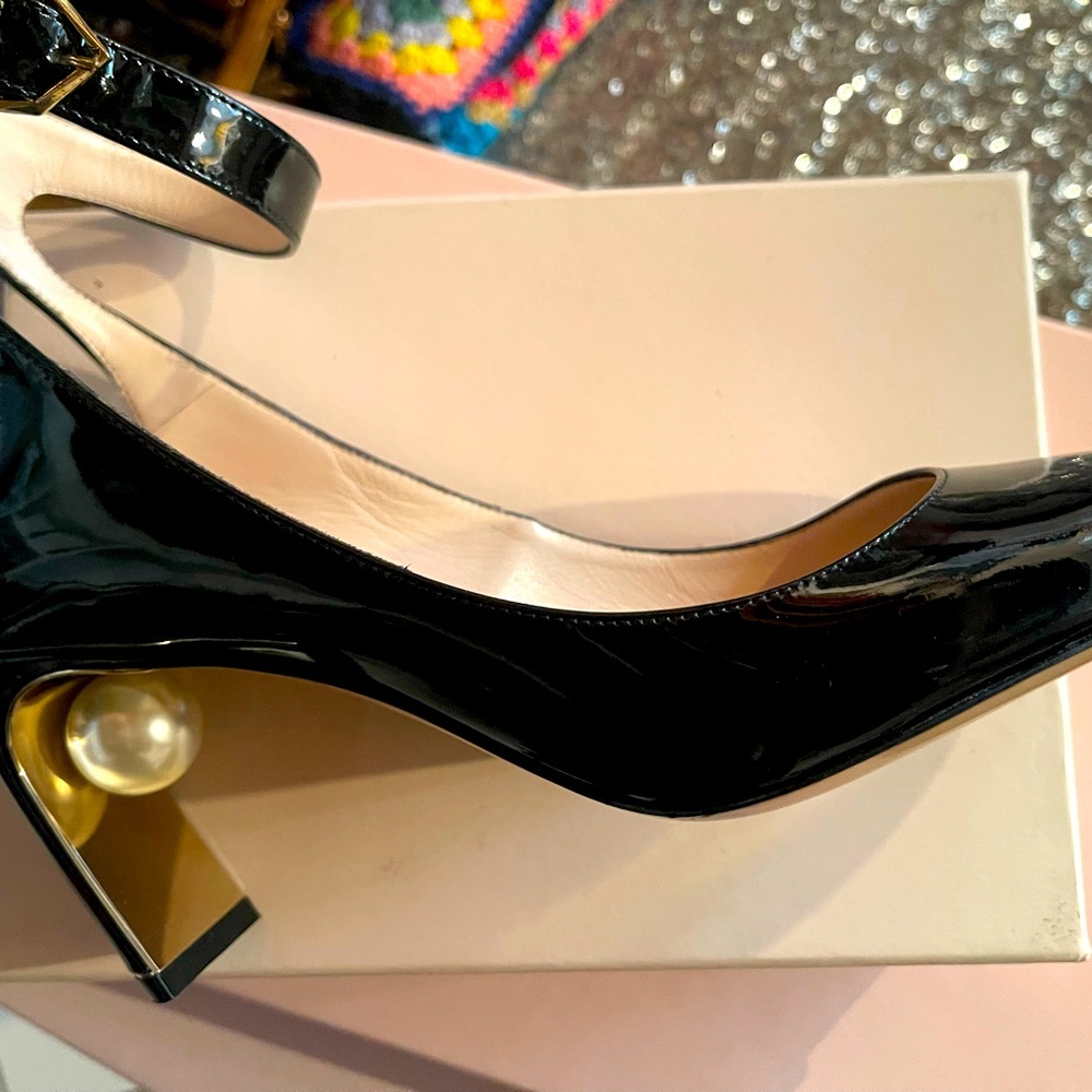 Nicolas Kirkwood black pump with large cream pearl under heel.